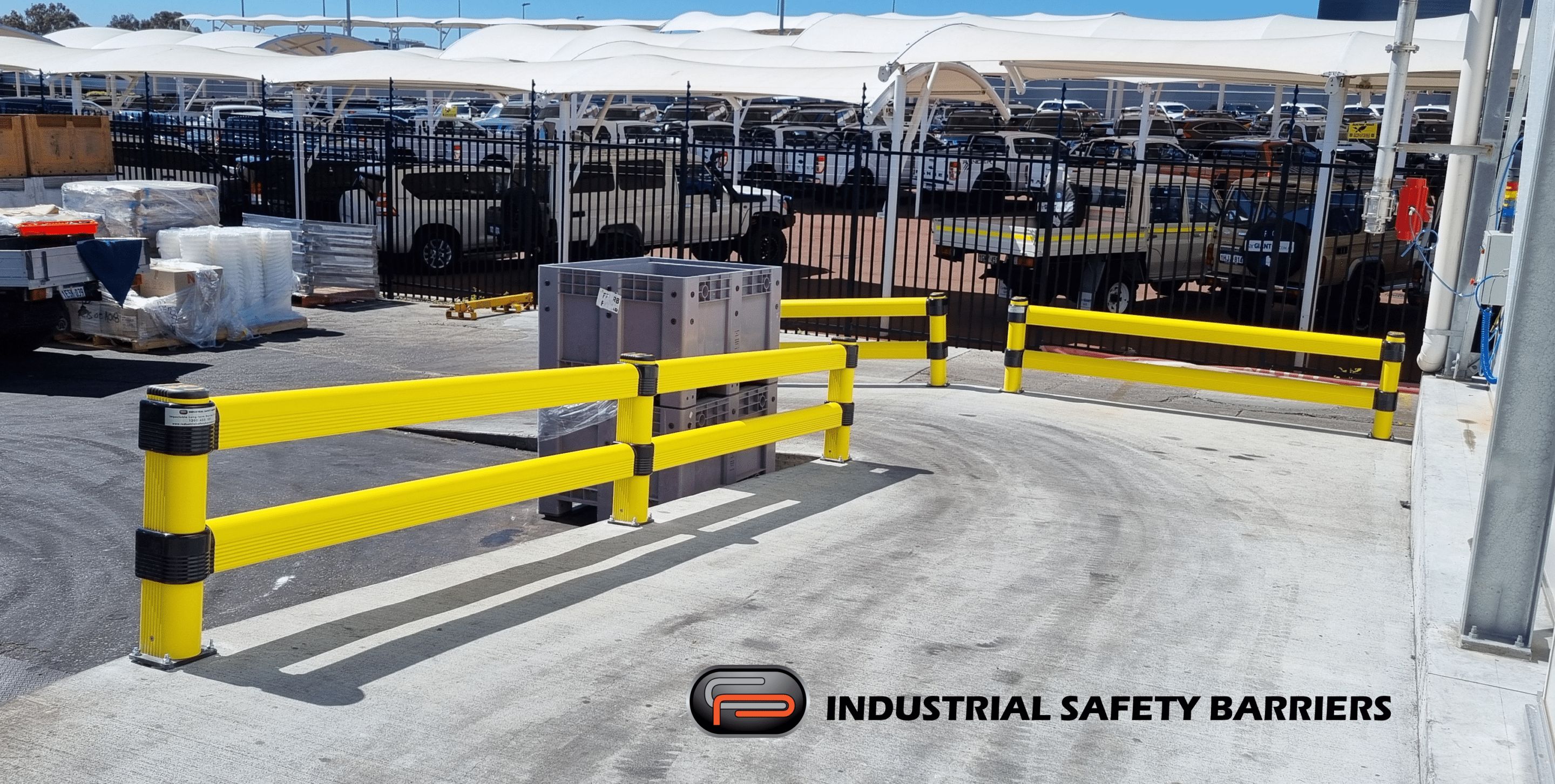 Yellow safety barriers and floor markings in a warehouse aisle.