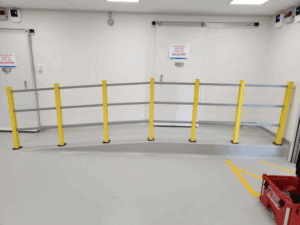 Safety railing installed along a small indoor access ramp.