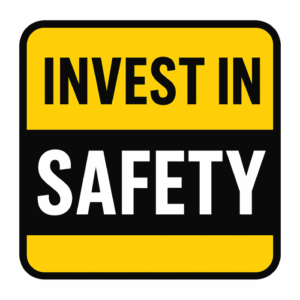 Yellow and black sign with the words “Invest in Safety.