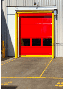 Bright red industrial roll-up door with yellow framing, installed on a warehouse exterior.